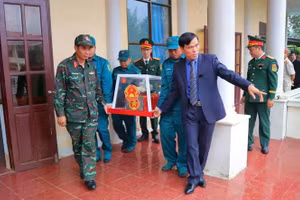 M. Le Viet Nam (au premier rang, à droite), secrétaire du Comité du Parti de la commune de Dak Pek, accompagne les restes des soldats morts pour la Patrie jusqu’à leur lieu d’inhumation. Photo : fournie par le Comité populaire de la commune.