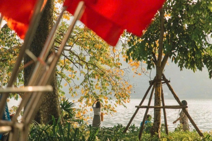 Touristes photographiant les feuilles dorées au bord du lac Hoan Kiem début septembre. Photo : Nguyen My Linh 30584da9b0a53afb63b4-175852884-4808-4916-1758528918-11zon.jpg