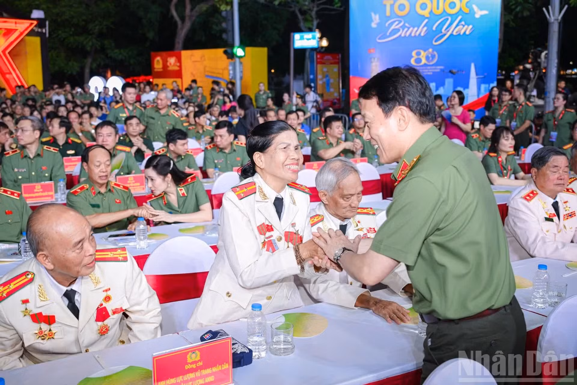 Le général Luong Tam Quang, membre du Bureau politique et ministre de la Sécurité publique, salue et échange avec les Héros des Forces armées populaires du secteur de la sécurité.