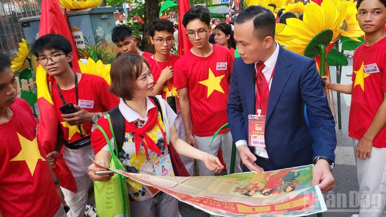 Un journaliste du Nhân Dân présente le supplément spécial au professeur associé, docteur Nguyen Tuan Anh, vice-doyen de la faculté de technologie chimique de l’Université de l’Industrie de Hanoï, à l’occasion de la Fête nationale. q4.jpg
