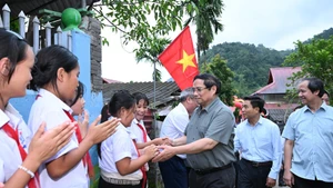 Le PM Pham Minh Chinh et des élèves de la commune montagneuse de Bat Mot. Photo : Tran Hai /NDEL