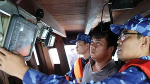 Vérification d’un dispositif de suivi installé à bord d’un bateau de pêche. Photo : VNA.