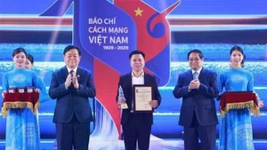 Le Premier ministre Pham Minh Chinh (deuxième, à droite) et le président de la Commission de l'information, de l'éducation et de la mobilisation de masse du Comité central du Parti, Nguyen Trong Nghia (deuxième à gauche), remettent un prix à un représentant des journalistes de VietnamPlus lors de la cérémonie du 21 juin. Photo : VNA. 