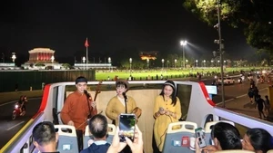 Les touristes admirent les sites de la capitale, tout en appréciant le Xâm traditionnel. Photo : VNA.
