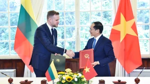 Le ministre vienamien des Affaires étrangères, Bui Thanh Son (à droite) et son homologue lituanien Gabrielius Landsbergis échangent des documents de coopération bilatérale, en octobre 2023. Photo : baoquocte.vn