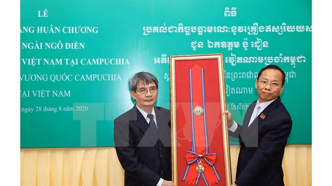 L'ambassadeur du Cambodge au Vietnam Chay Navuth a remis l'Ordre à un représentant de la famille de feu l'ambassadeur. Photo : VNA
