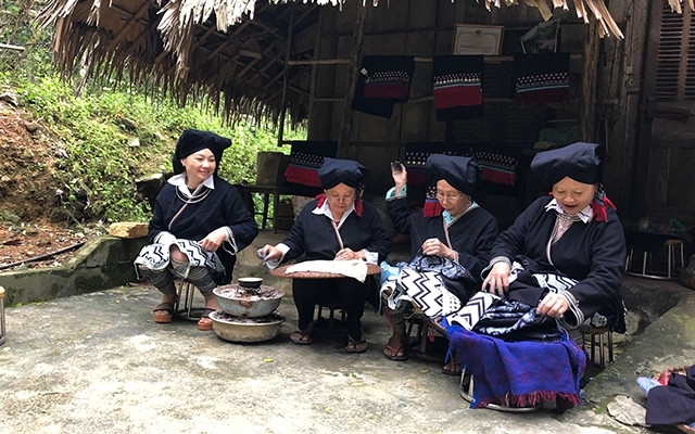 Les femmes Dao au village Sung démonstrent la peinture sur la brocatelle. Photo : NDEL.