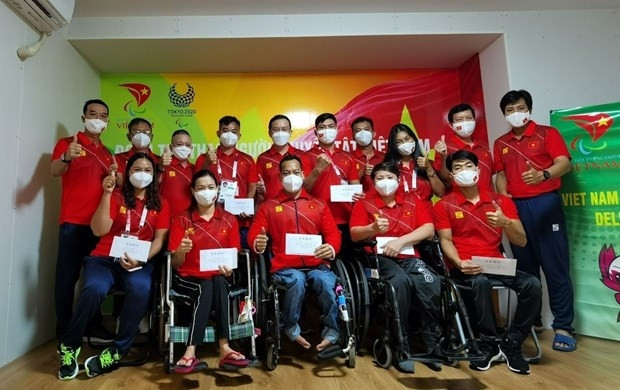 La délégation sportive vietnamienne prend une photo souvenir au Village des athlètes à Tokyo. Photo : VNA.