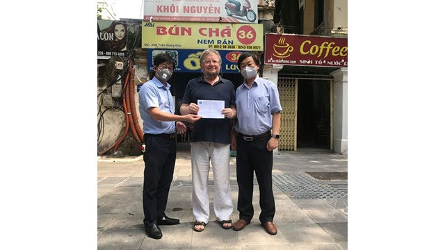 Le vice-président de l'Association d'amitié Vietnam - Russie à Hanoï, Cao Vo lui remet une somme de 3 millions de dôngs à Andrey Pavlovich Shulydin. Photo: Journal Thoi Dai