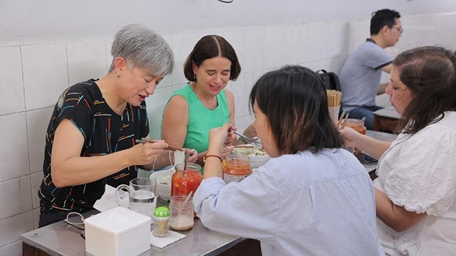 Le ministre des Affaires étrangères Wong (chemise noire) et l'ambassadrice Mudie (chemise bleue) prennent du "phở". Photo : Ambassade d'Australie au Vietnam.