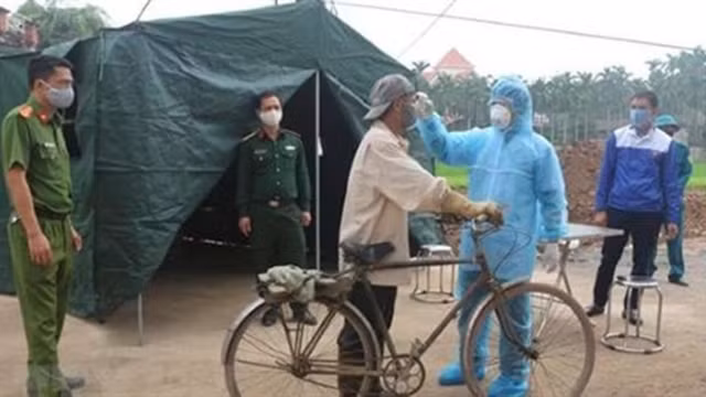 Un agent médical vérifie la température d'un habitant à Hà Nam (au Nord). Photo : VNA.