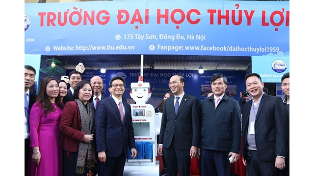 Le Vice-Premier ministre Vu Duc Dam et la vice-ministre de l’Éducation et de la Formation Ngô Thi Minh visitent les stands. Photo : VNA.
