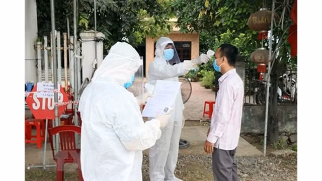 Contrôle de la température corporelle d'un homme à Quang Nam. Photo : VNA.