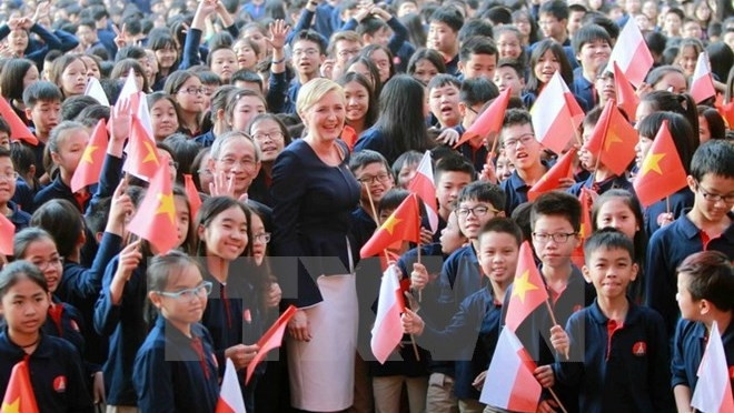 L’épouse du Président polonais Agata Kornhauser-Duda prend une photo souvenir avec des élèves du lycée de Marie Curie. Photo: VNA.