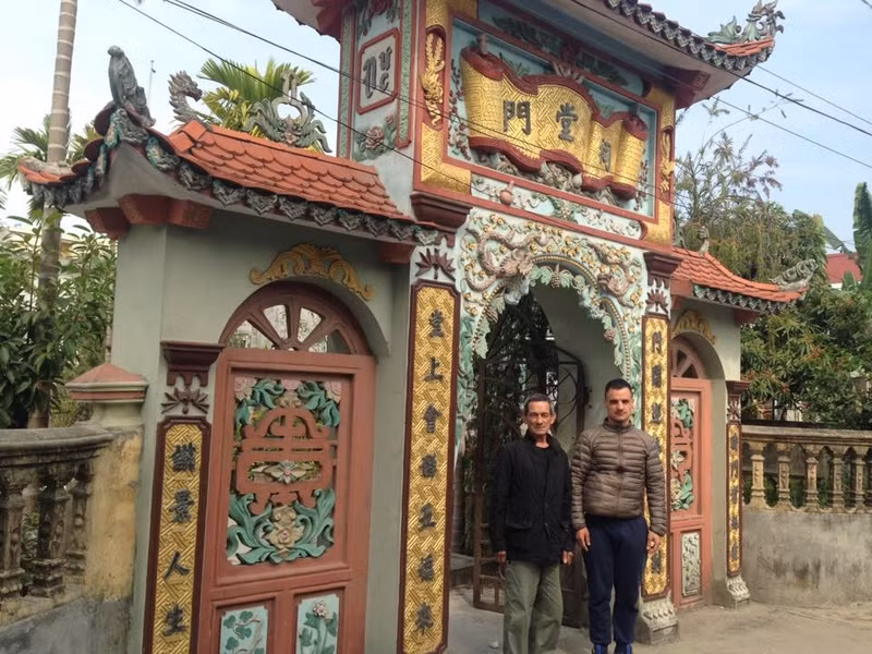 M. Guy Pacini et son fils Jean Christophe devant la maison de culte de la grande famille Nguyên de sa grand-mère, dans la ville de Hai Phong. Photo: Hà An/NDEL.