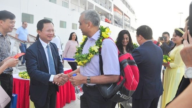 Le vice-président du Comité populaire provincial de Quang Ninh, Cao Tuong Huy (aux lunettes), offre des fleurs aux visiteurs. Photo: VNA.