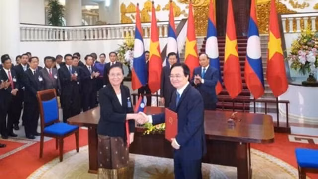 Le ministre vietnamien de l’Éducation et de la Formation Phung Xuân Nha (à droite) et la ministre laotienne de l’Éducation et du Sport Sengdeuane Lachanthaboune signent l’accord sur la coopération dans l'éducation et le développement de ressources humaines pour la période 2021-2030. Photo : giaoducthoidai.vn