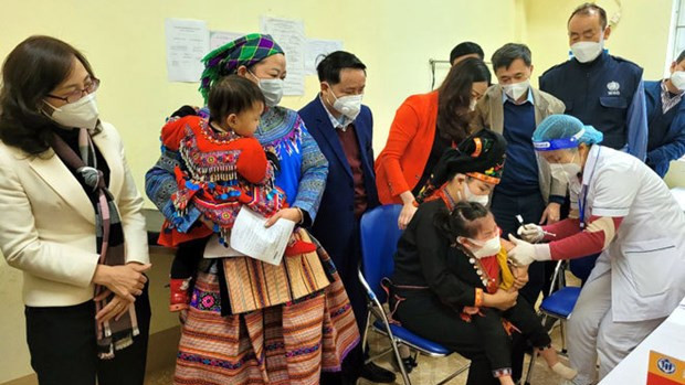 Le Directeur régional de l'OMS pour le Pacifique occidental et la délégation observent la vaccination d’enfants dans la station médicale de la commune de Dai Son. Photo : baoyenbai.com.vn