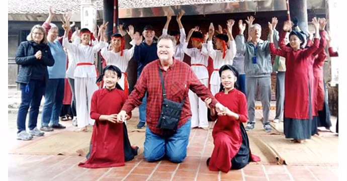 Les visiteurs étrangers participent au spectacle « hat xoan ». Photo: Journal Phu Tho