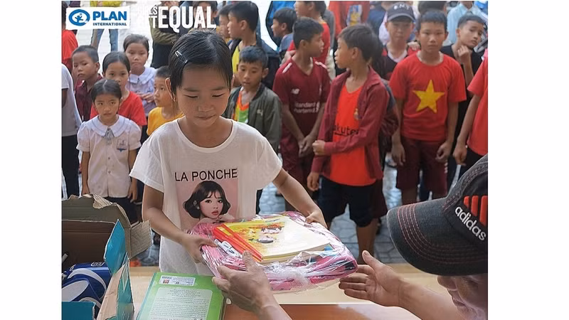 Une fille reçue de fournitures scolaires. Photo : thoidai.vn.