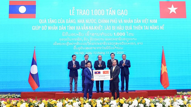 Sous le témoignage des Premiers ministres des deux pays, le vice-ministre des Affaires étrangères Nguyên Quôc Dung a remis symboliquement le don de 1 000 tonnes de riz à l'ambassadeur adjoint du Laos au Vietnam Chanthaphone Khammanichanh. Photo : https://baoquocte.vn