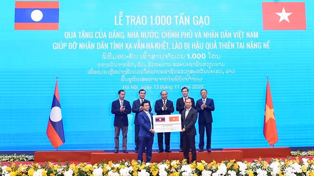 Sous le témoignage des Premiers ministres des deux pays, le vice-ministre des Affaires étrangères Nguyên Quôc Dung a remis symboliquement le don de 1 000 tonnes de riz à l'ambassadeur adjoint du Laos au Vietnam Chanthaphone Khammanichanh. Photo : https://baoquocte.vn