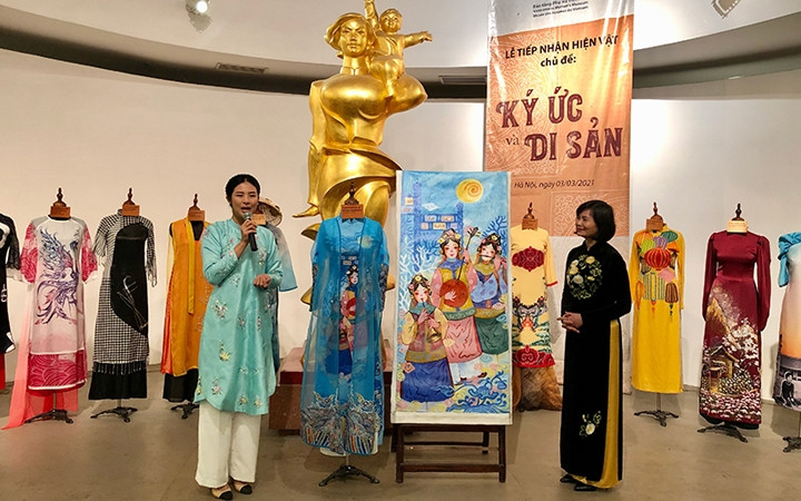 Miss Vietnam 2010 Dang Thi Ngoc Hân remet ses créations "Áo dài" à une représentante du musée des femmes du Vietnam, lors de la cérémonie. Photo : NDEL.