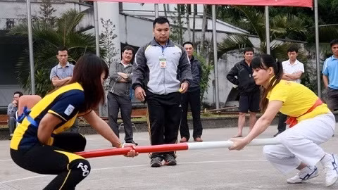 Des sportives dans la compétition de la poussée au bâton. Photo: VNA.