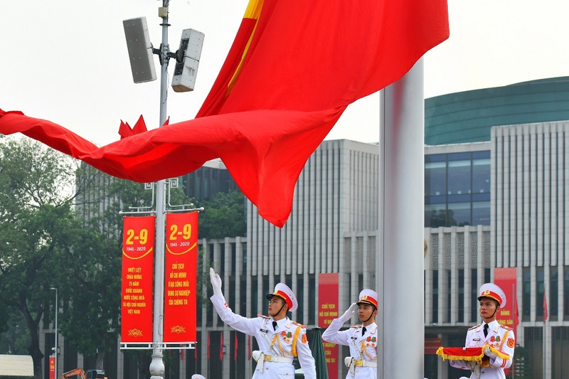 Le drapeau national flotte sur fond de la musique de l'hymne national sur la place Ba Dinh. Photo : NDEL.
