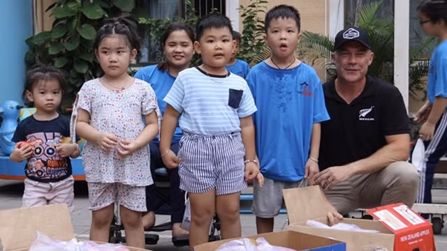Le consul général de Nouvelle-Zélande à Hô Chi Minh-Ville, Joe Nelson, fait don de fruits aux enfants au Village Chance. Photo : VNA.