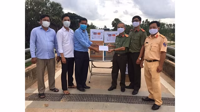 Le chef adjoint du service de police du district de Tân Hung, Vo Dan Dinh offre le matériel médical pour lutter contre le COVID-19 au district cambodgien de Svay Chrum. Photo: http://cand.com.vn