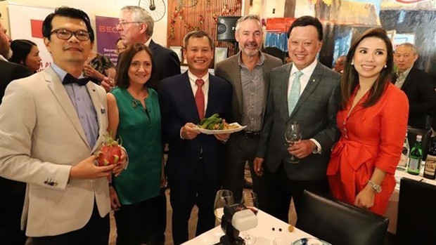 Des délégués montrant des fruits vietnamiens lors de l'événement. Photo : VNA.