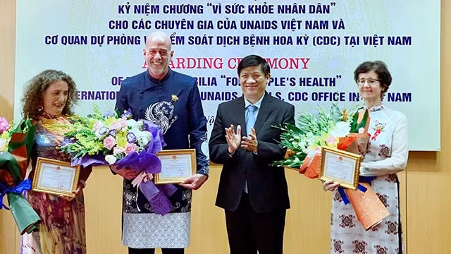 Le ministre vietnamien de la Santé par intérim, Nguyên Thành Long (2e à droite), remet l’Insigne « Pour la santé du peuple » à trois responsables médicaux étrangers. Photo : VNA