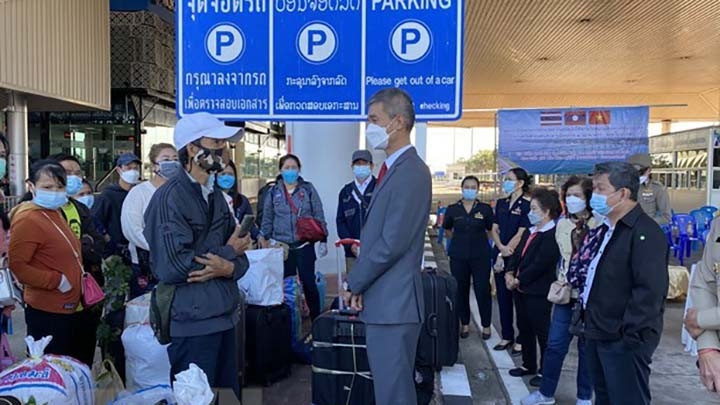 Le consul général Chu Duc Dung (à droite) dit au revoir à des citoyens vietnamiens avant leur retour au Vietnam. Photo : VNA.