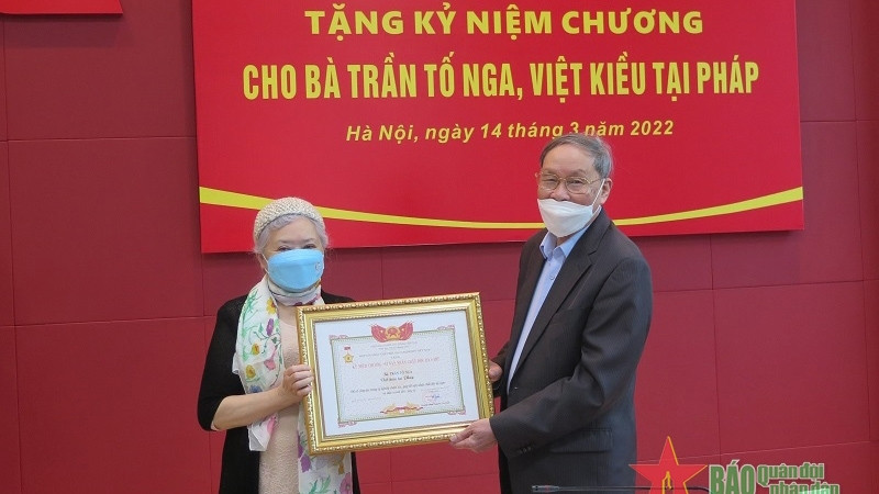 Remise de l’insigne « Pour les victimes de l’agent d’orange » à Trân Tô Nga. Photo: qdnd.vn