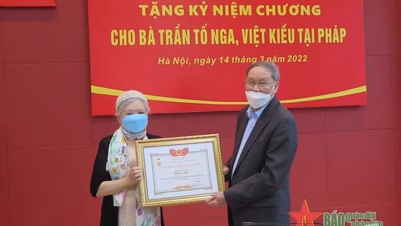 Remise de l’insigne « Pour les victimes de l’agent d’orange » à Trân Tô Nga. Photo: qdnd.vn