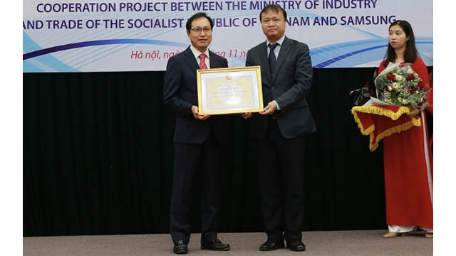 Le vice-ministre de l’Industrie et du Commerce Dô thang Hai remet le satisfecit décerné à la Sarl Sam Sung Electronics Vietnam au directeur général de Samsung Vietnam Choi Joo Ho. Photo: NDEL