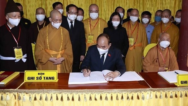 Le Président Nguyên Xuân Phuc écrit dans le registre de condoléances. Photo : VNA.