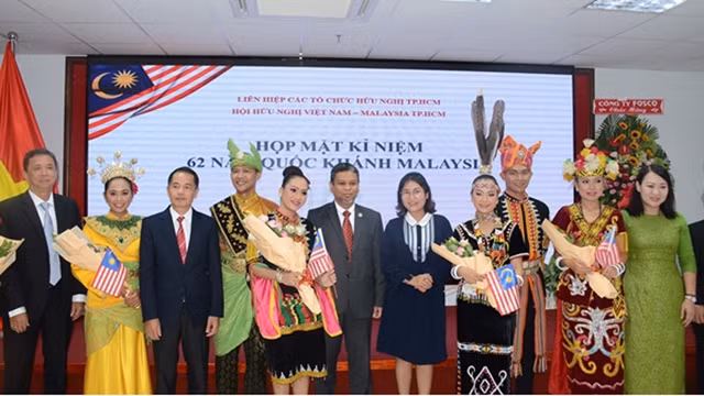 Photo entre des invités et des artistes lors de la rencontre d’amitié. Photo : voh.com.vn.