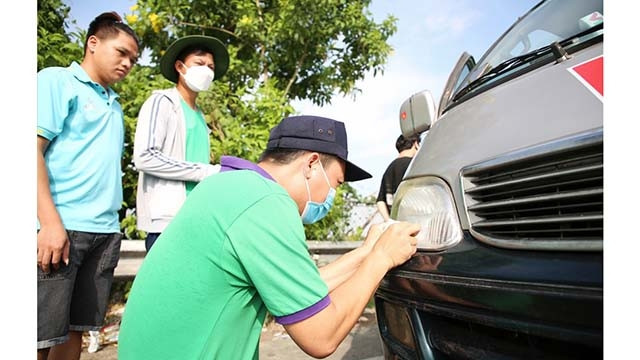 L'installation de la carte de télépéage prépayée ETC (Electronic Toll Collection) sur une voiture. Photo : laodong.vn