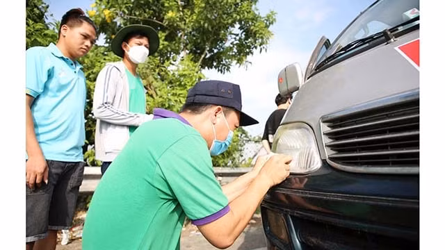 L'installation de la carte de télépéage prépayée ETC (Electronic Toll Collection) sur une voiture. Photo : laodong.vn