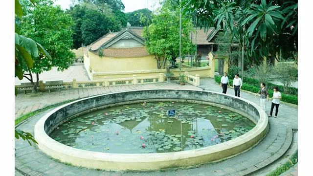 Les touristes visitent l'étang « Yeux du dragon » et la maison communale du village de Dông Ngac. Photo : NDEL.