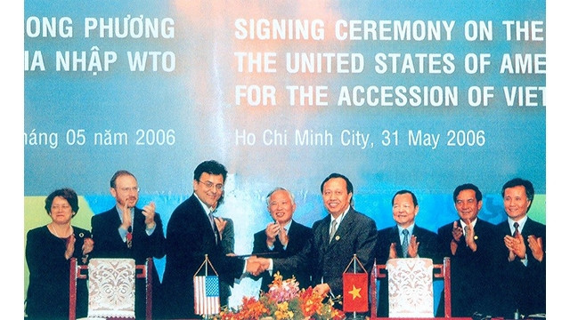 La cérémonie de signature de l'accord d'adhésion à l'OMC avec les États-Unis entre Bhata Karan, représentant adjoint de l'USTR et Luong Van Tu, vice-ministre de l'industrie et du commerce, chef de l'équipe de négociation pour adhérer à l'OMC, en présence du vice-Premier ministre Vu Khoan. Photo: baoquocte.vn
