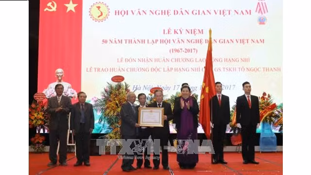 La vice-présidente permanente de l’Assemblée nationale, Tong Thi Phong (1er plan, 3e à droite), a remis, le 17 décembre, à Hanoï, l'Ordre de l'indépendance de 2e classe du président vietnamien à Tô Ngoc Thanh. Photo : VNA