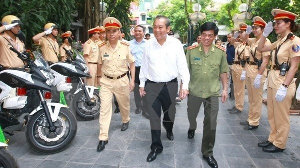 Le vice-PM vietnamien, Truong Hoa Binh (au milieu, chemise blanche), et des resposables du Département de la Police routière. Photo: VNA.