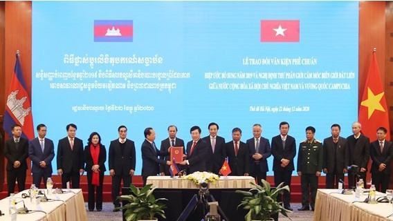 Le vice-Premier ministre et ministre des Affaires étrangères Pham Binh Minh (à l'avant, à droite) remet le document de ratification à l'ambassadeur du Cambodge Chay Navuth le 22 décembre à Hanoi. Photo: VNA