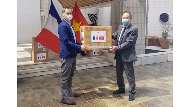 L'ambassadeur du Vietnam en France, Nguyên Thiêp (à droite), remet des masques médicaux au président de l'Union générale des Vietnamiens de France, Vuong Huu Nhan. Photo : VNA.