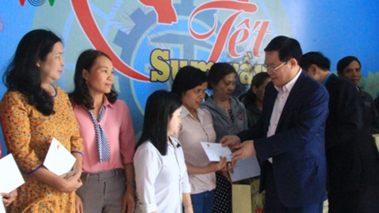 Le vice-Premier ministre Vuong Dinh Huê remet des cadeaux aux travailleurs en difficulté. Photo: VOV