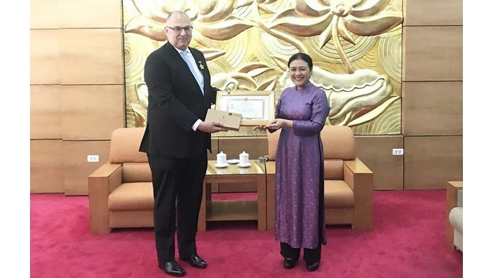 L’ambassadrice Nguyên Phuong Nga, présidente de l’Union des Organisations d’Amitié du Vietnam, remet l’insigne "Pour la paix, l’amitié entre les nations” à l’ambassadeur du Danemark, Kim Højlund Christensen. Photo : baoquocte.vn