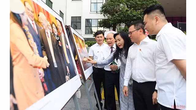 Le rédacteur en chef du Journal Nhân Dân, Lê Quôc Minh, et les délégués lors de l'exposition. Photo : NDEL.